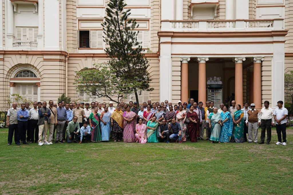 A group of Indian senior citizens gathered outdoors at a science museum in Kolkata