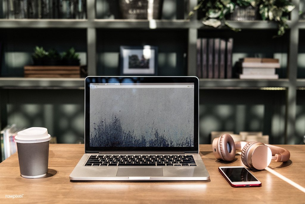 A laptop on a desk in a shared coworking space