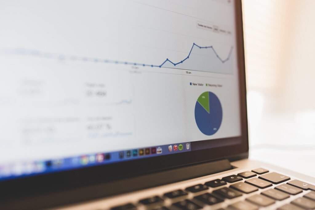 A laptop screen showing a line chart and a pie chart on an analytics dashboard