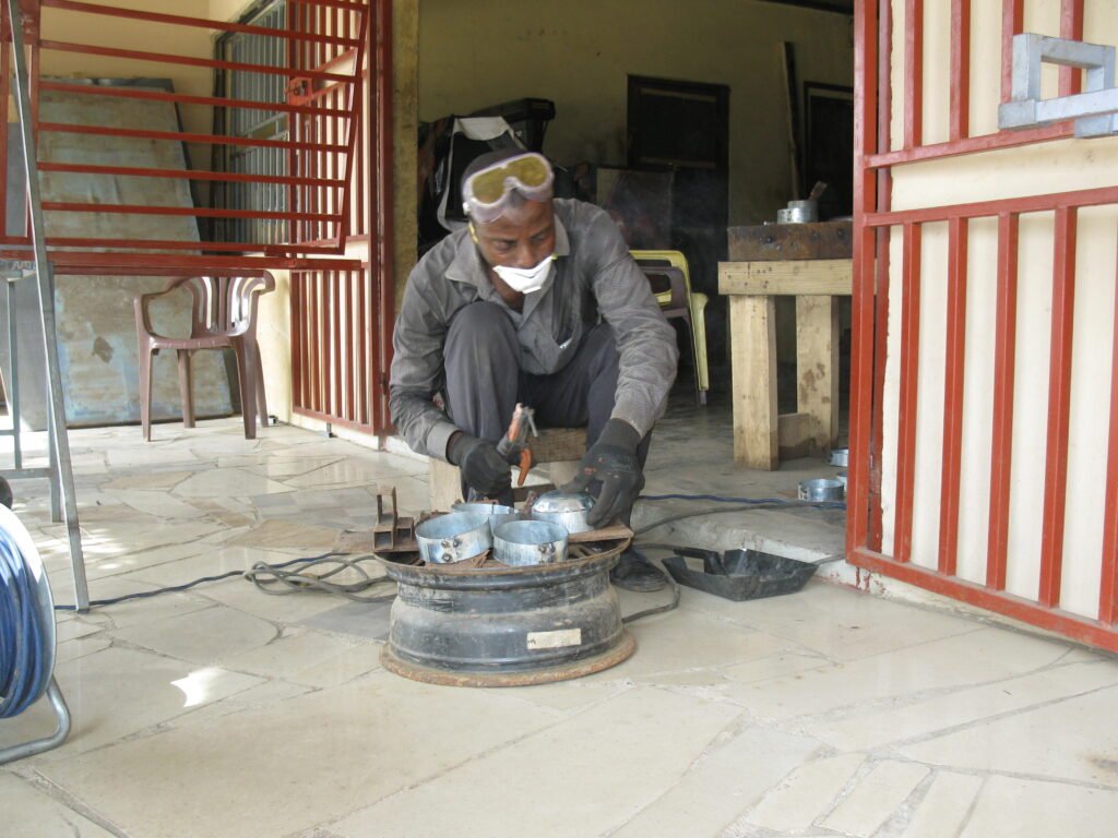 A metal fabricator welding a steel plate in a workshop