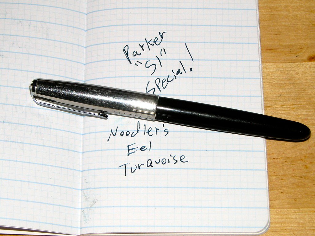 A Parker 51 fountain pen resting on paper