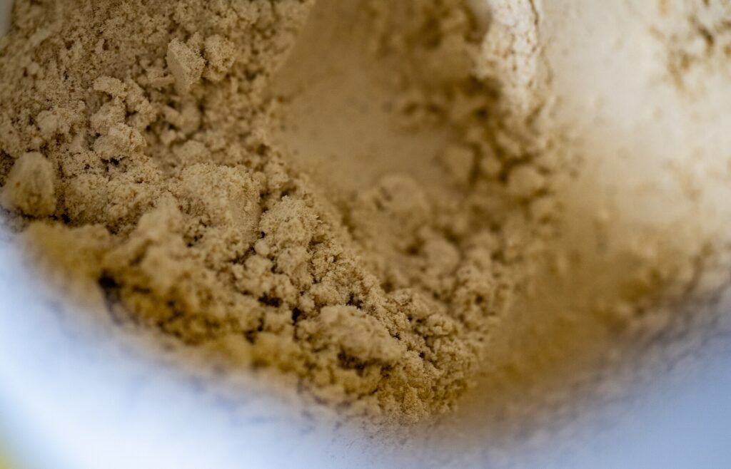 A scoop of protein powder being mixed in a container