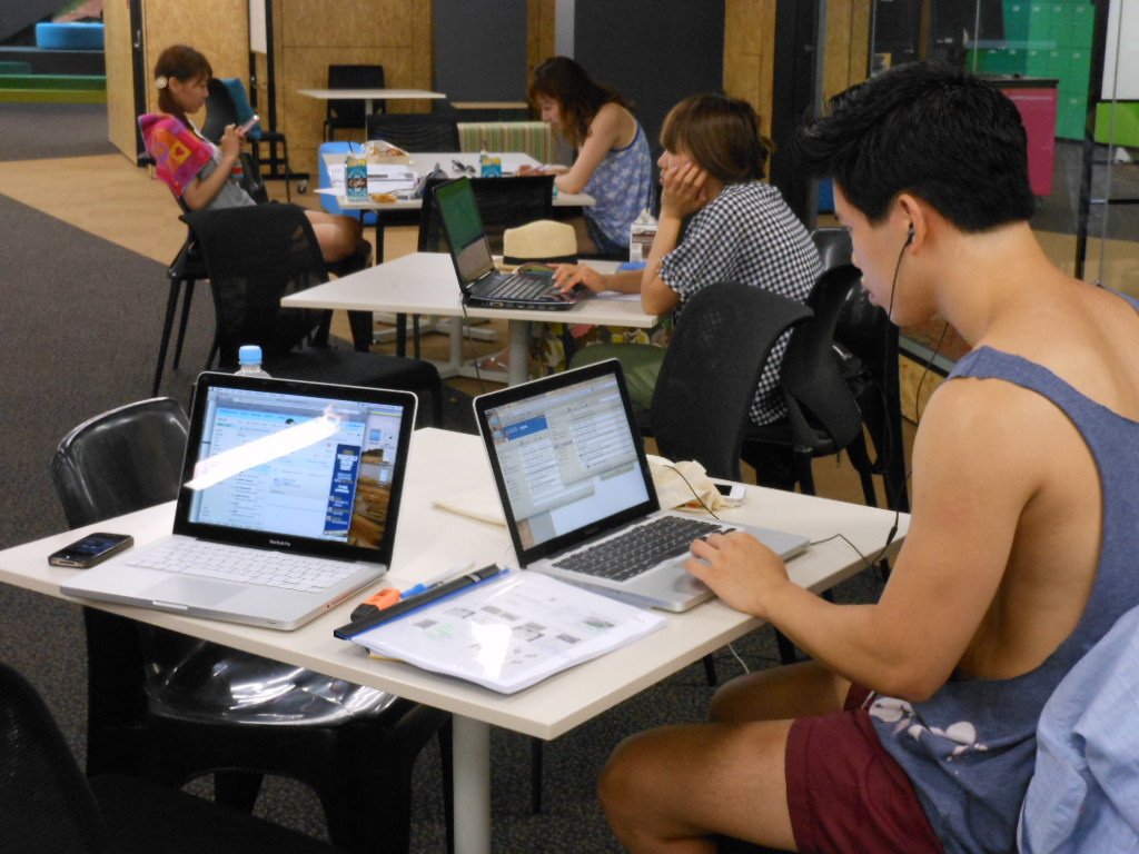 A student studying with a laptop and notes on a desk