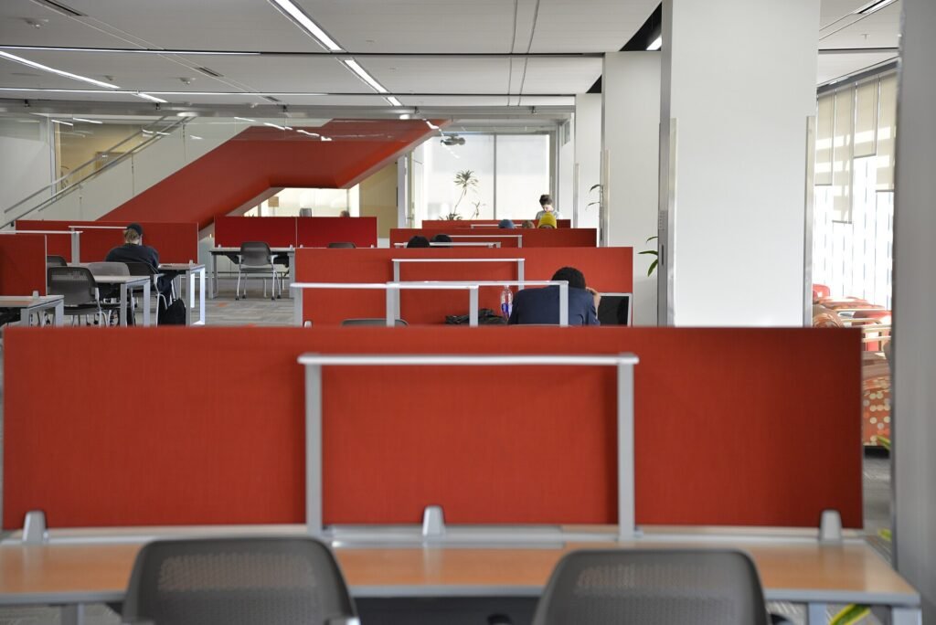 A study area on the third floor of a college building where students work with laptops and books
