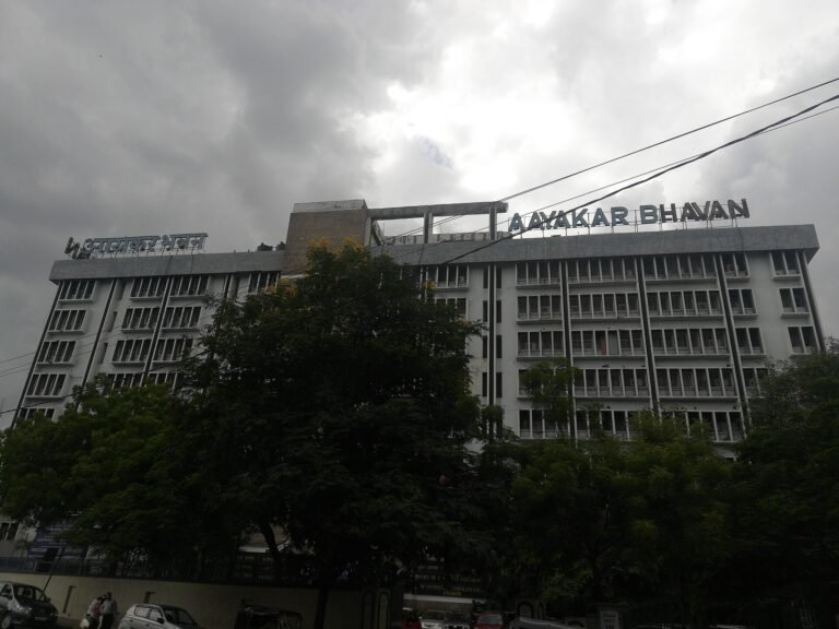 Aayakar Bhavan, an Income Tax Department office building, behind trees under a cloudy sky