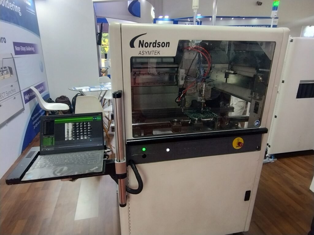 An automated Nordson Asymtek dispensing machine for circuit board assembly on display at a trade show