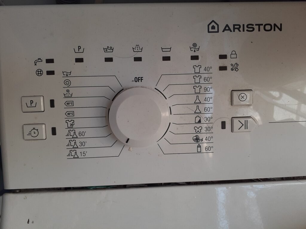 Close-up of a washing machine control panel with a programme dial and buttons