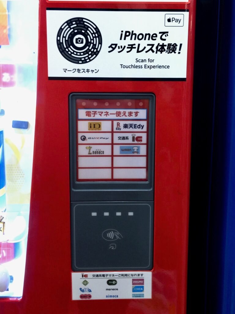 Contactless payment reader on a vending machine with an Apple Pay sticker