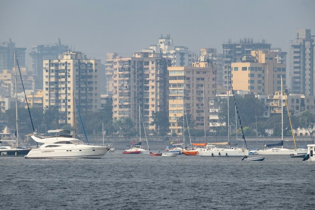 Mumbai skyline seen across the sea with sailing boats in the foreground
