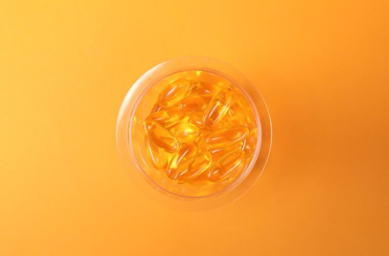 Omega-3 supplement capsules spilling out of a bottle