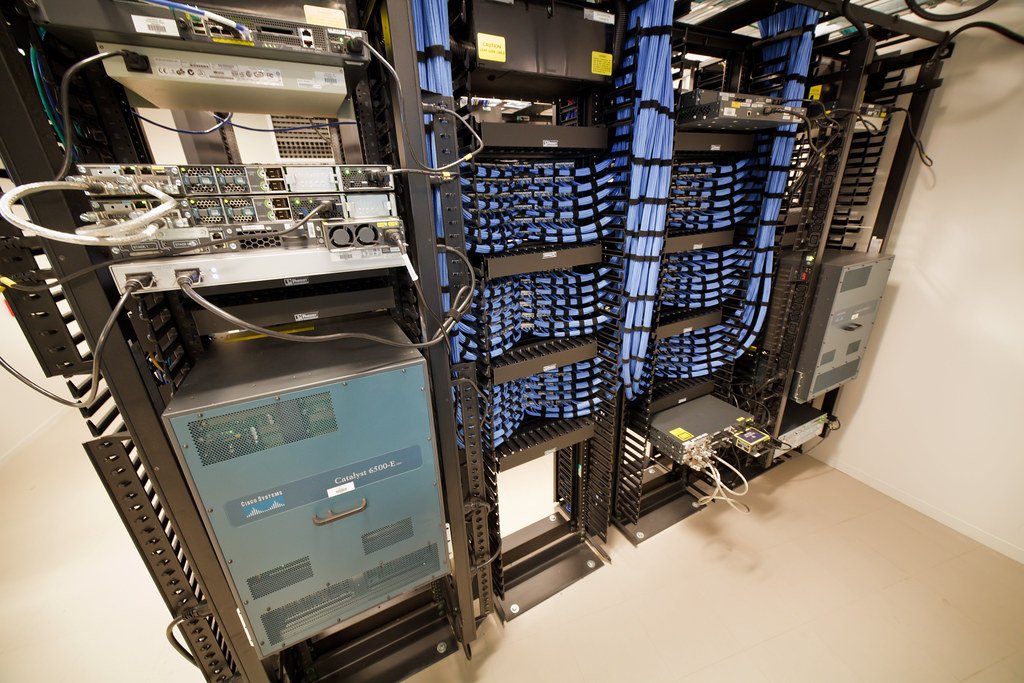 Rows of networking equipment and cables at the core of a data center
