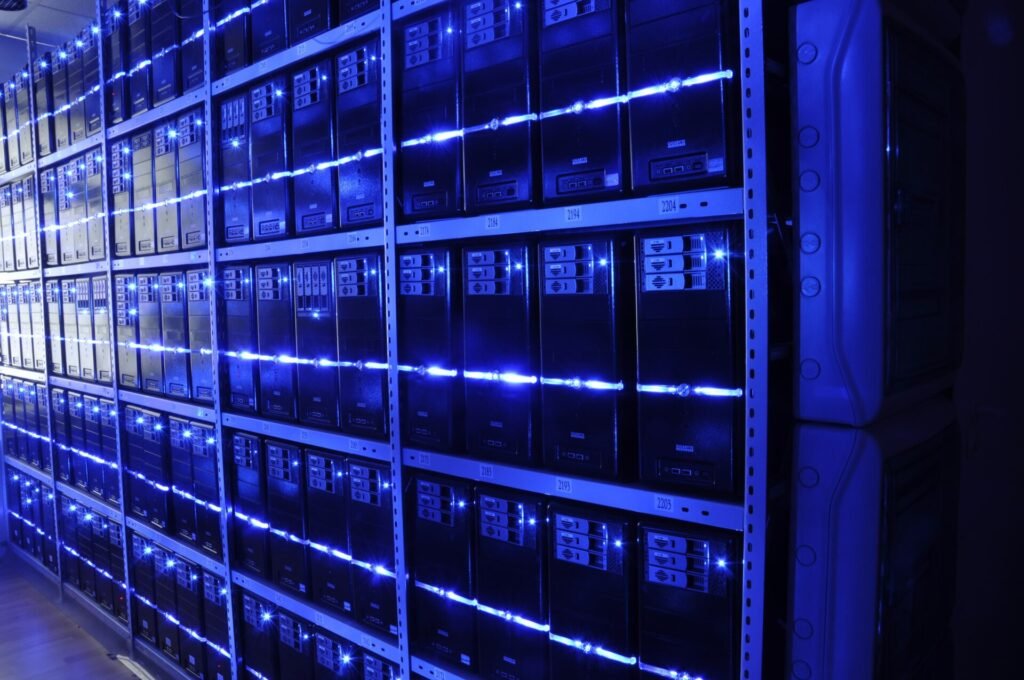 Rows of server racks with blue lights in a data centre