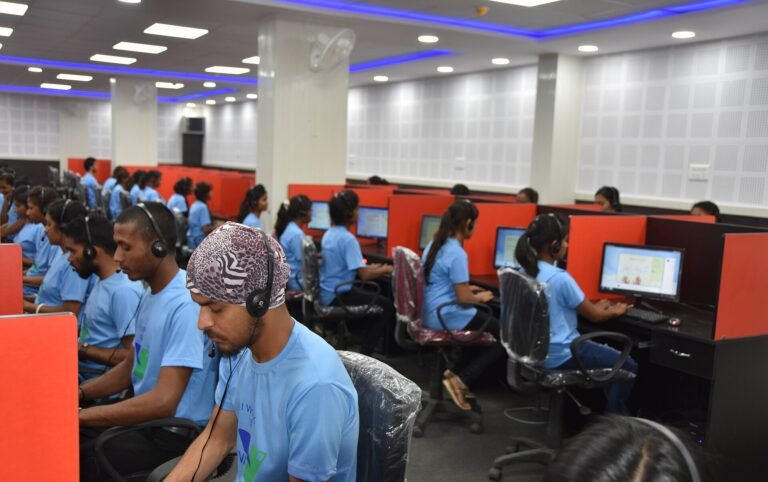 Rows of staff working at computers with headsets in a business process outsourcing centre in Dantewada, India