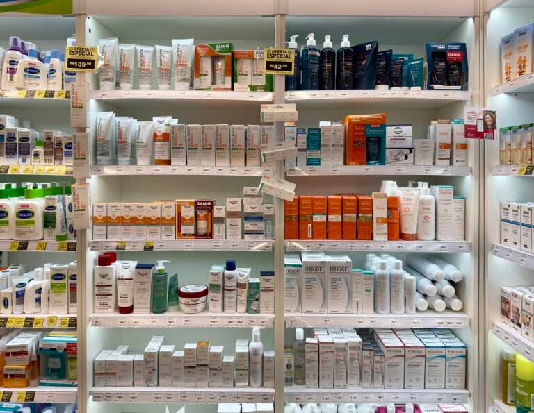 Shelves of skincare creams, lotions and cleansers in white tubes and bottles at a pharmacy