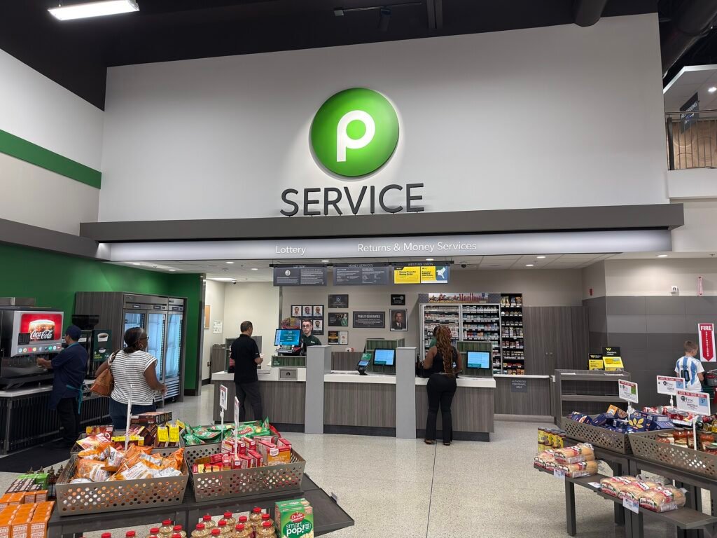 Staff serving shoppers at a supermarket customer service desk