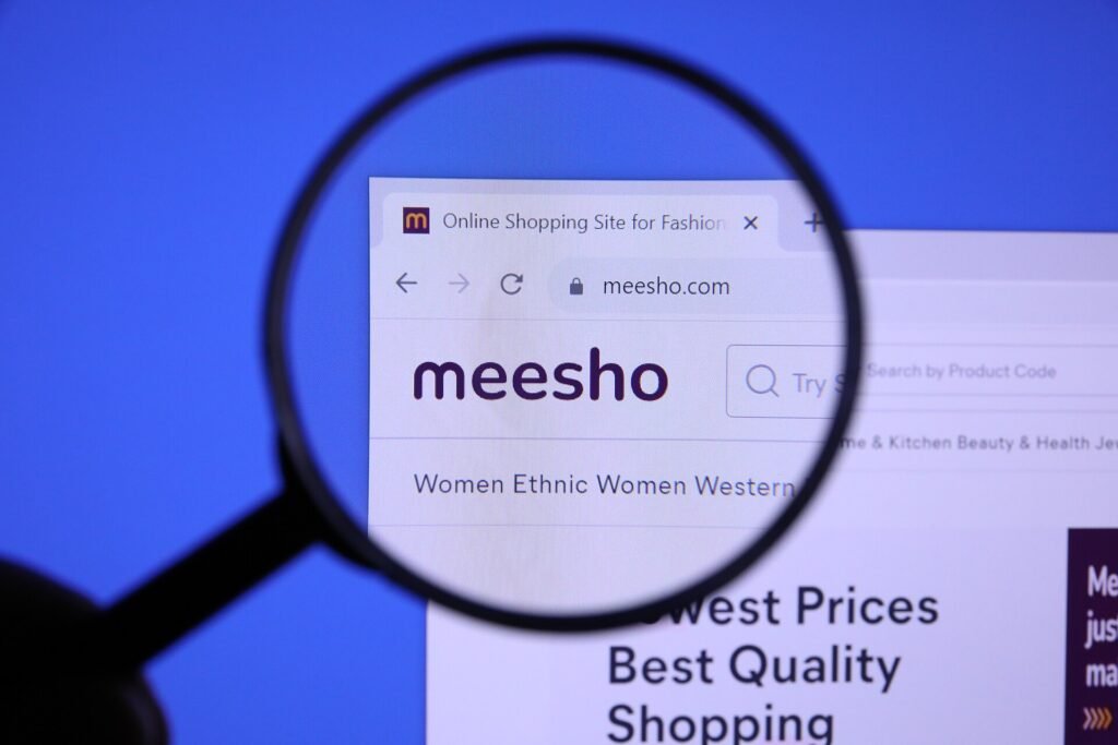 The Meesho website open in a browser, seen through a magnifying glass