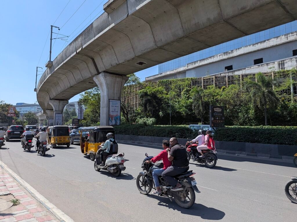 Traffic of motorbikes and auto-rickshaws under the elevated metro line in Hyderabad’s HITEC City