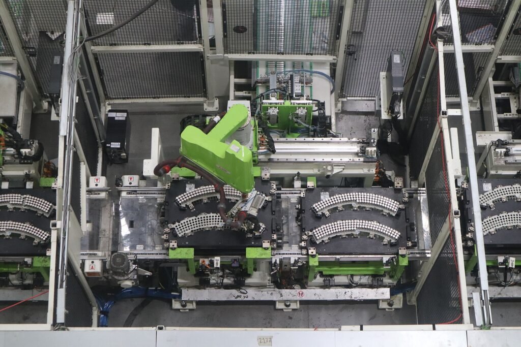 Workers assembling electric scooter battery packs on a factory line